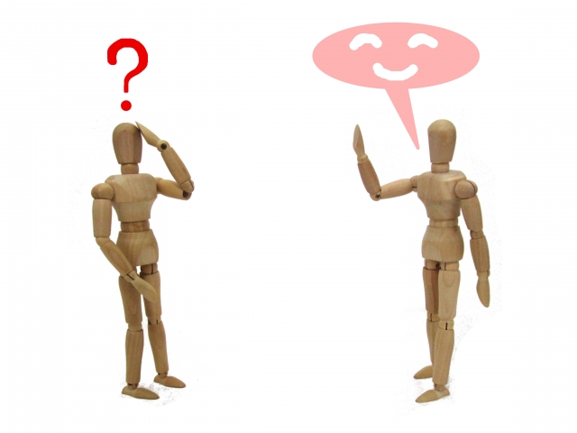 会話をする二体の木製人形のイメージ写真