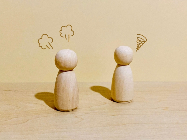 不満を感じる人と戸惑う人を表す木製の人形
