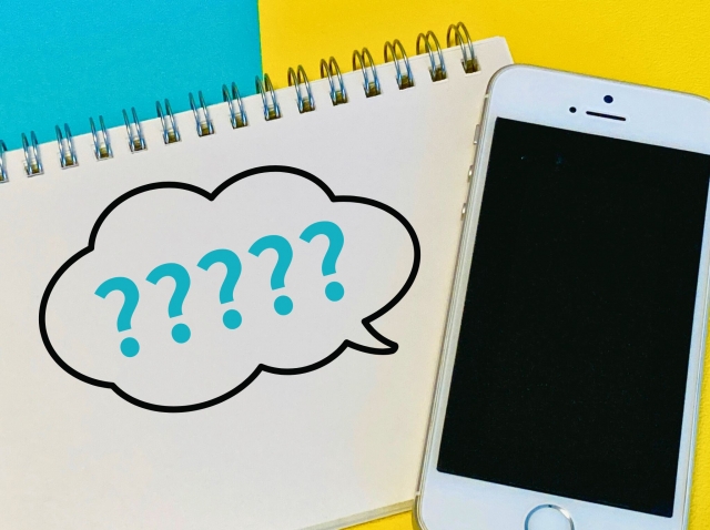 ノートとスマートフォンの横に浮かぶ疑問符のイメージ写真|店長が数字の優先順位に迷う場面を表現