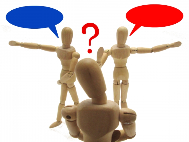 意見が分かれて迷っている様子を表した木製フィギュアのイメージ画像