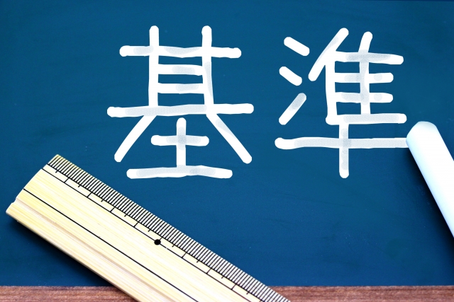 黒板に書かれた「基準」の文字と定規の写真
