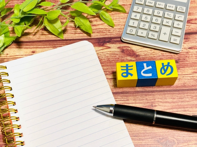 ノートとペン、電卓と「まとめ」のブロックを並べた写真