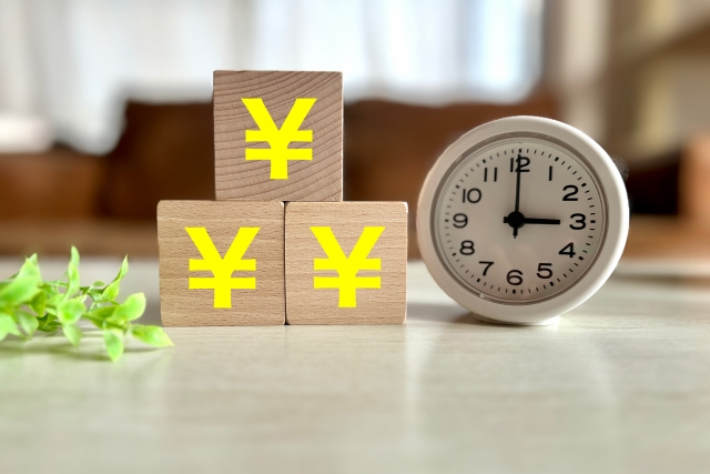 時計と円マークの積み木を並べた、時間と売上をイメージした写真