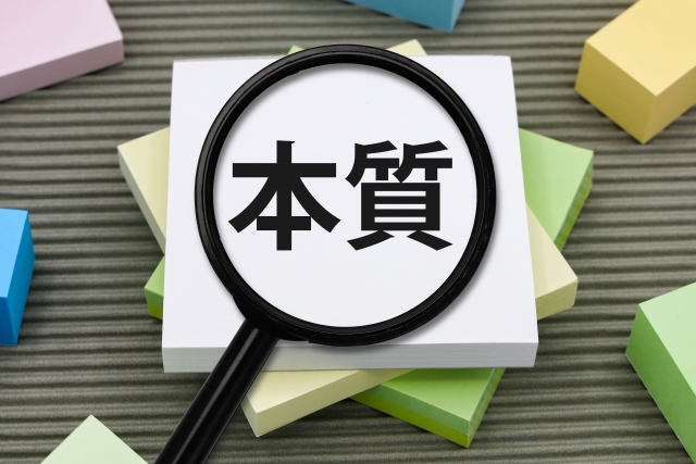 「本質」の文字を虫眼鏡で拡大している写真