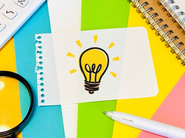 電球のイラストが描かれたメモ用紙と文房具の写真