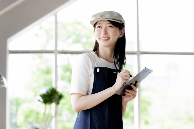 メモを取る飲食店スタッフが笑顔で対応している様子
