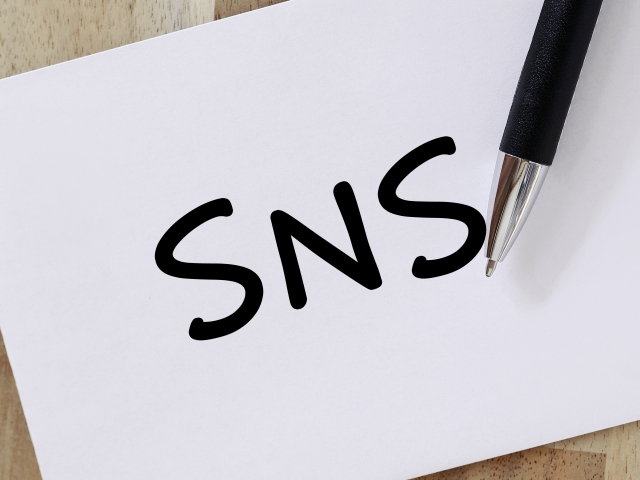 SNSの文字とペンを写したイメージ写真