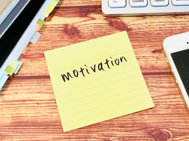 モチベーションと書かれた付箋を机に置いたイメージ画像