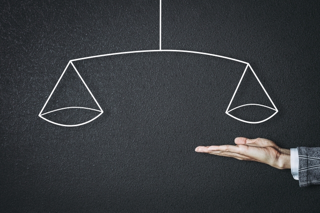 忙しい飲食店で教育と業務のバランスを取るイメージ(手の上に描かれた天秤の写真)