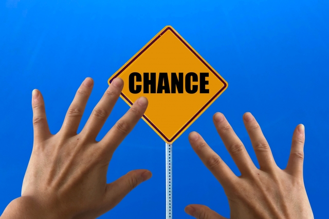 「CHANCE」と書かれた標識に手を伸ばす写真